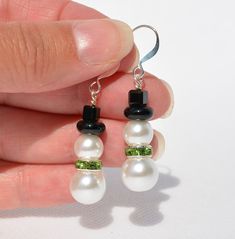 Festive Christmas Snowmen Earrings handmade with white glass 'pearl' beads.  Great to wear throughout the holiday season, or give as gifts for co-workers, teachers, friends, and family!  8mm and 10mm white pearls bead snowmen with black hat and your choice of red, green, or clear crystal scarves.  Silver-plated ear wire -  (1-4)  Two-layer Snowmen earrings - overall earring length is 1.75 inches.  (5-6) Three-layer Snowman with hat earrings - overall earring length is 2 inches (7)  Three-layer Snowman earring without hat - overall earring length is 1.75 inches Please check out all my other listings for free shipping on combined items totaling $35+   Brenda's All About Beads shop includes Gemstone Pendants, Gemstone Earrings, Swarovski Crystal Earrings, Shell Earrings, Shell Pendants, Paua Elegant White Earrings For Holiday, Elegant White Holiday Earrings, White Christmas Jewelry With Matching Earrings, White Christmas Jewelry Set With Matching Earrings, White Drop Earrings For Holiday, Adjustable White Crystal Earrings For Gift, White Drop Earrings For Holidays, White Dangle Christmas Jewelry, White Holiday Dangle Jewelry