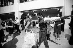 a man and woman dancing on the dance floor at a wedding reception in black and white