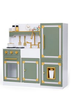 a green and white play kitchen with gold trimmings on the doors, drawers, and shelves