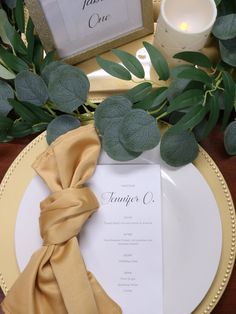 a place setting with napkins and greenery