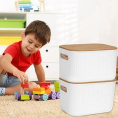 a young boy playing with wooden blocks on the floor in front of a storage unit