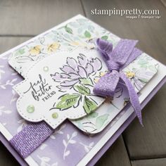 a close up of a greeting card with flowers on it and a purple ribbon tied around the edge