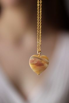 This delicate unique necklace was made of natural mother of pearl beige heart pendnat and high quality gold tone stainless steel chain with gold tone lobster claw. The chain is from lead & nickel free metal. Perfect jewelry for everyday wear and a great gift for someone special! The length of necklace is 45 cm or 17.7 inches. Other necklaces of my shop you can see here: https://www.etsy.com/shop/NaTavelli?section_id=14843046&ref=shopsection_leftnav_5 Thanks for a visit. Agate Pendant Necklaces With Adjustable Chain, Agate Pendant Necklace With Adjustable Chain, Jade Pendant Necklaces For Crafting, Elegant Heart Pendant Jewelry For Healing, Gold Chalcedony Jewelry As A Gift, Resin Pendant Necklace With Lobster Clasp, Gift Necklaces With Round Beads And Heart Charm, Gift Necklace With Heart Charm And Round Beads, Elegant Agate Jewelry With Adjustable Chain