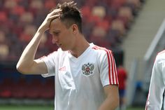 a soccer player holds his head while standing on the field