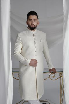 This White Long Sherwani is a stunning choice for your special occasion. Made from printed off-white khaadi silk, it features a silk kurta and cotton pajama for a comfortable fit. Complete your look with the elegant organza Rajastjhani kula (turban) and exude an air of style and sophistication. Elegant White Cotton Silk Sets, Elegant Cotton Silk Kurta With Cutdana, White Cotton Silk Bandhgala With Resham Embroidery, Fitted White Cotton Silk Kurta, White Fitted Cotton Silk Kurta, Elegant Cream Cotton Silk Traditional Wear, Bollywood Style Cotton Silk Kurta For Weddings, Bollywood Style Cotton Silk Wedding Kurta, Bollywood Style Wedding Kurta In Cotton Silk