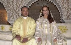 a man and woman dressed in white sitting on a couch