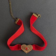 Bronze Heart Pendant on Red Velvet Ribbon Choker Capture the essence of timeless romance with this Bronze Heart Pendant elegantly set on a rich Red Velvet Ribbon Choker. This Vintage Style Red Necklace exudes charm and sophistication, featuring a Romantic Heart Charm that makes it an ideal Embellished Choker for any special occasion. The intricately designed bronze heart pendant offers a touch of antique allure, beautifully complemented by the luxurious red velvet ribbon. The combination of vint Red Velvet Ribbon, Aesthetic 2023, Velvet Necklace, Ribbon Choker, Ribbon Jewelry, Romantic Heart, Vintage Ribbon, Red Necklace, Velvet Ribbon