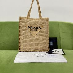 SHOP MORE LUXURY PRODUCTS HERE Description Prada Raffia Tote Bag Beige For Women, Women’s Bags 14.9in/38cm This tote bag with a soft, deconstructed design is made of raffia, a material of natural origin imbued with a summery mood. A new interpretation of the emblematic Prada triangle decorates the front and is embellished with the embroidered lettering logo at the center. Size: 38 x 36 x 3 cm /14.9 x 14.2 x 1.2 inches (Length x Width x Height) BeigeRaffia handlesEmbroidered lettering logo Prada Raffia Tote Bag, Prada Raffia, Raffia Tote Bag, Prada Triangle, Embroidered Lettering, Prada Re Edition, Louis Vuitton Shirt, Chanel Shirt, Triangle Bag