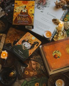 a table topped with lots of books and candles