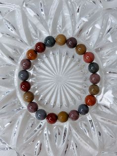 "You will receive one stunning, high quality Alashan Agate bracelet. A natural mix of warm, rainbow colours. This beaded crystal bracelet is made \"one size\", and stretches to fit. It measures roughly 6.75 cm in diameter, and the beads measure 9mm. * * * * * ABOUT ALASHAN AGATE: Alashan agate is a type of agate that is known for its unique patterns and colors. It is a semi-precious gemstone that is found in the Alxa League of Inner Mongolia, China.  Yanyuan agate, named after Yanyuan County in Sichuan, China, is a variety of banded chalcedony, a mineral of the quartz family. They are known for their diverse and striking colors, usually forming in volcanic rocks or limestones. ❀ * * * * * Follow me on Instagram: instagram.com/ambers.expressions" Earthy Multicolor Beaded Bracelets With Natural Stones, Earthy Multicolor Beaded Bracelet With Natural Stones, Multicolor Agate Beaded Bracelets, Multicolor Agate Beaded Bracelets With Round Beads, Spiritual Agate Crystal Bracelet With Colorful Beads, Brown Crystal Bracelet With Gemstone Beads, Rainbow Crystal Bracelet With Gemstone Round Beads, Rainbow Crystal Bracelet With Natural Stone Round Beads, Multicolor Agate Hand-strung Crystal Bracelet