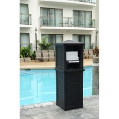 a black trash can sitting next to a swimming pool