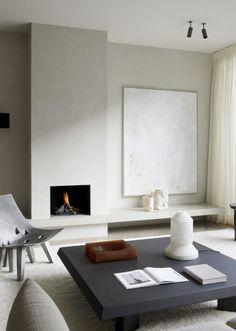 a living room with white furniture and a fire place in the fireplace, as well as a painting on the wall