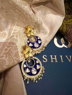 These gorgeous earrings will add a perfect charm to your occasion wear. You will definitely fall in love with this beauty and it will make you stand out among the crowd. Length: 6.5 cms Width: 3.5 cms One of a kind. The uncut Kundan stones embellished on a blue meenakari (enameled) base with pearl drop clusters make it a statement pair. The earrings are the same as shown in the pictures. We have only one piece in this design and color, hence you get what you see in the pictures. Kundan Hoop Earrings As A Gift, Gift Chandbali Bridal Earrings, Chandbali Bridal Earrings For Gift, Gift Kundan Hoop Earrings With Latkans, Kundan Hoop Earrings With Latkans For Gift, Kundan Bridal Earrings With Latkans For Gift, Festive Chandbalis Drop Earrings As Gift, Festive Gift Chandbalis Drop Earrings, Blue Latkan Danglers For Wedding