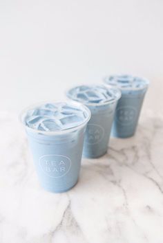 three blue cups sitting on top of a marble counter