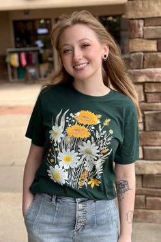 Daisy Floral Boho Graphic Tee Forest Green T-shirt color with ivory and yellow flowers This updated unisex essential fits like a well-loved favorite, featuring a crew neck, short sleeves and designed with superior combed and ring-spun cotton that provides amazing softness. Features: Sideseamed. Retail fit. Unisex sizing. Shoulder taping. Fabrication: 100% ring-spun cotton Fits TTS with a Unisex Fit. Printed on Bella Forest. Green Pre-shrunk Tops For Spring, Spring Crew Neck T-shirt In Ring-spun Cotton, Spring Cotton T-shirt With Screen Print, Spring Short Sleeve T-shirt In Ring-spun Cotton, Spring Short Sleeve Ring-spun Cotton T-shirt, Spring Ring-spun Cotton Short Sleeve T-shirt, Green T-shirt For Everyday Spring Wear, Spring Organic Cotton Relaxed Fit T-shirt, Spring Relaxed Fit Organic Cotton T-shirt