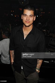 a young man standing in front of a crowd at a nightclub with his hands on his hips