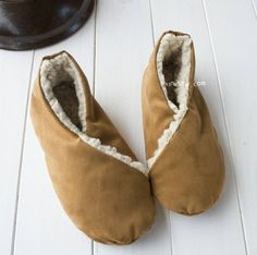 a pair of brown slippers sitting on top of a white floor