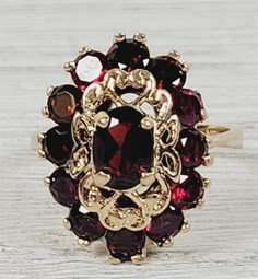 "L-2064  Vintage 1960's Garnet 14K Yellow Gold Ring 7.5 Cluster Retro Luxury Design  AMAZING VINTAGE 1960's NATURAL GARNET CLUSTER COCKTAIL SOLID 14K GOLD RING. WEAR ALONE ON WITH YOUR STACK. WONDERFUL COLOR & HIGHEST QUALITY. WONDERFUL HIGHEST QUALITY. JUST PART OF MY MOST RECENT ESTATE FINDS! FOLLOW ME TO SEE THEM ALL!    Brand: Unbranded Metal: 14K Yellow Gold Metal Purity: 14K Material:  Ring Size: 5.5 Other Dimensions: 3/4\" Form: Ring Luxury Age: Vintage Weight (Grams): 5.4 IT IS IN EXCELL Vintage 14k Stamped Cluster Rings, Vintage 14k Gold Cluster Ring Hallmarked, Vintage Yellow Gold Cluster Ring, Vintage Gold Cluster Ring With Gemstones, Vintage Yellow Gold Cluster Jewelry, Vintage Oval Cluster Ring With Gemstone, Vintage 14k Gold Cluster Jewelry, Vintage Style Red Cluster Ring In 14k Gold, Vintage Gemstone Cluster Ring