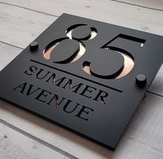 a black sign with the number 55 on it that says summer avenue in gold lettering