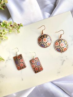 Give a Truly Special Gift with a Handmade Piece by a Skilled Jewelry Artist. We create our copper handmade jewelry with modern printing techniques. 🌟 New version of our best seller. ⁃ Our copper accessories are high quality, durable, and famous paintings are printed in high resolution on engraved natural copper plate. Material: SURFACE TYPE: Copper THICKNESS: 0.4 mm Clasps Type: ⁃ Lobster Claw Sizes: ⁃ Round Diameter : 1.5  in / 4cm  ⁃ Rectangle 1.5 in (4cm) x 1.2 in (3cm) How to Order: - Choose quantity and add to cart. After you can check our other models and fill the cart, you can make a secure payment via Etsy Payments. - After the order has been completed we will start to prepare your package for delivery. Please don't forget to add your contact number for fast and trouble-free shipp Multicolor Nickel-free Copper Earrings, Nickel-free Multicolor Copper Earrings, Handmade Multicolor Copper Earrings, Artisan Multicolor Brass Earrings, Multicolor Copper Dangle Earrings, Copper Accessories, Copper Plate, Jewelry Artist, Light Weight Jewelry