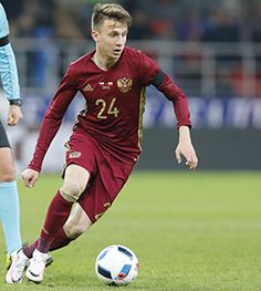 a soccer player is running with the ball in front of two other players during a game