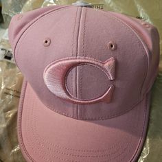 a pink hat with the letter c on it