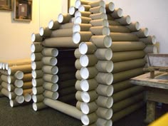 several stacks of pipes are stacked on top of each other in an office area with a workbench behind them