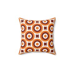 an orange and brown pillow with circles on it's side, against a white background