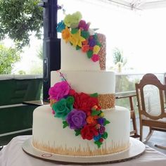 a three tiered cake decorated with colorful flowers