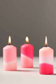 three candles with pink and white frosting on them