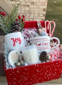 a red box filled with christmas items and candy canes on top of a table