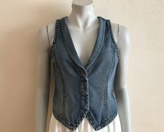 Women's Vest Blue Denim Vest Jeans Vest Fitted Womens Waistcoat Country Western Boho Womens Vest Sleeveless Denim Jacket Suit Collar  Measurements (lying flat): Length(back): 18.5"/ 47 cm Pit to pit: 16.5"/ 42 cm Waist: 15 1/4"/ 39 cm Please check measurements to insure a proper fit. Remember to allow yourself some extra room for movement. You can compare these with something from your closet that fits you well. Please convo me if you need additional measurements. Condition: great Vintage Condit Stretch Denim Blue Vest For Spring, Spring Stretch Denim Blue Denim Vest, Spring Stretch Denim Vest, Fitted Blue Denim Vest Top, Fitted Casual Denim Vest For Spring, Blue Denim Vest Top For Spring, Casual Denim Vest Top For Spring, Casual Spring Denim Vest Top, Spring Casual Denim Vest Top