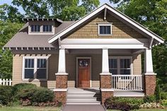 a small brown and white house with porches on the front door, steps leading up to it's second floor