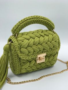 a green handbag with a tasselled handle