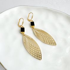 This season, glow for gold in this statement pair with trendy geometric shapes. GEMSTONE: Onyx MATERIAL: Signature brushed gold plating on brass CLOSURE: Gold plated leverback LENGTH: 2.75" long Gold Geometric Jewelry For Party, Chic Gold Geometric Jewelry, Chic Geometric Gold Jewelry, Gold Geometric Earrings For Party, Geometric Gold Earrings For Party, Trendy Gold Geometric Earrings, Gold Statement Earrings, Geometric Earrings, Brushed Brass