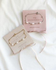 two bridesmaid bracelets and a card on a bed