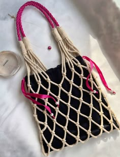 a black and white bag with pink handles