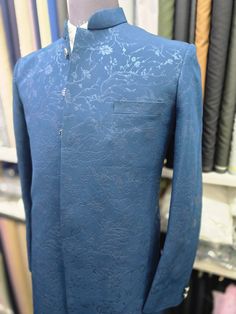 a mannequin wearing a blue shirt and tie in front of a rack of clothing