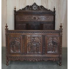 an old wooden bed with carvings on it