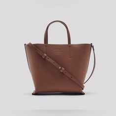 Brand New In Original Packaging! Everlane The Luxe Italian Leather Crossbody Bag In Brown For Women's. Color: Brown Features: -100% Italian Leather -Small Size -Adjustable Cross-Body Strap -Leather-Covered Metal Snap Button Closure -Interior Zip Pocket Fit: Bottom Width: 22cm / 8.6in Top Width: 28.5cm / 11.2 In Height 21.5cm / 8.5in Depth 10.5cm / 4.1in Pocket 18cm / 7in Wide X 12.5cm / 4.9in High Handle Drop 11cm / 4.3in Smallest Strap Length: 101.5cm / 40in Thank You For Checking Out My Listin Cognac Everyday Bag With Adjustable Strap, Everyday Cognac Bag With Adjustable Strap, Leather Crossbody Bag For Shopping, Tan Crossbody Bucket Bag With Removable Pouch, Classic Crossbody Box Bag For Shopping, Classic Leather-handled Crossbody Box Bag, Everyday Top Handle Leather Bag, Everyday Top Handle Bag With Leather Handles, Daily Top Handle Bag With Leather Handles