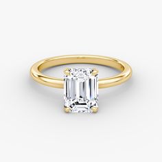 an emerald cut diamond engagement ring in yellow gold