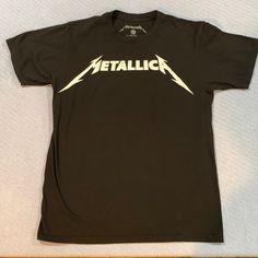 This Metallica T-Shirt Is 100% Cotton. It Is New Without Tags. Has A Vintage Weathered Look. See Photo. Band Logo Graphic Tee With Crew Neck, Graphic Tee With Band Logo And Crew Neck, Band Merch Cotton Tops With Logo Print, Cotton Crew Neck Top With Band Logo, Black Band Merch T-shirt With Logo, Band Logo Crew Neck Tops, Band Logo Crew Neck Tops For Fans, Band Logo Graphic Tee With Short Sleeves, Black Band Logo Crew Neck Top