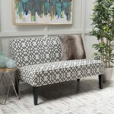 a couch sitting next to a potted plant on top of a hard wood floor