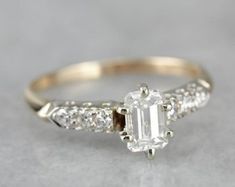 an emerald cut diamond ring with side stones