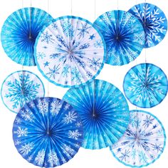 blue and white snowflaked paper fans hanging from strings on the wall, decorated with snowflakes