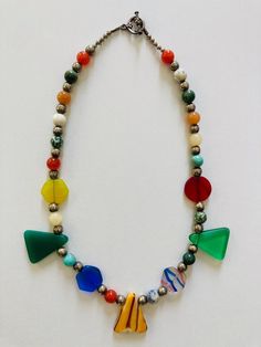 This beautiful necklace was designed to celebrate color. I used triangle, sphere, and hexagon beads to emphasize each different color. All the beads are sustainable and the product is ethically made. Multicolor Recycled Glass Beads For Jewelry Making, Multicolor Recycled Glass Jewelry For Jewelry Making, Multicolor Recycled Glass Bead Jewelry, Multicolor Recycled Glass Beaded Jewelry, Festival Glass Necklaces With Faceted Beads, Glass Necklaces With Faceted Beads For Festivals, Festival Glass Necklace With Faceted Beads, Glass Necklace With Faceted Beads For Festivals, Multicolor Recycled Glass Jewelry With Large Beads