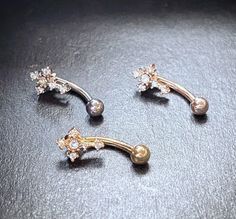 three pairs of gold and diamond earrings on a black surface, with one dangling from the side