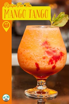 a close up of a drink in a glass on a table with the words recipe for the mango tango