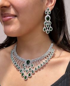 Add a touch of glamour and sophistication with this high quality necklace set in beautiful  emerald green stones. The stones in this set bling and look close to the real thing. This set is sure to make heads turn!  It features an adjustable necklace and a pair of earrings. It can be paired perfectly with both ethnic and western outfits.  In case of any queries, please feel free to reach out. Happy shopping! Anniversary Emerald Necklace With Cubic Zirconia Jewels, Hand-set Cubic Zirconia Emerald Necklace For Wedding, Cubic Zirconia Emerald Necklace For Wedding, Hand-set Cubic Zirconia Emerald Necklace For Party, Hand Set Emerald Necklace With Cubic Zirconia For Party, Hand Set Cubic Zirconia Emerald Necklace For Party, Fine Jewelry Hand-set Emerald Necklace For Party, Green Stone Setting Jewelry Sets For Wedding, Green Stone-setting Jewelry Sets For Wedding