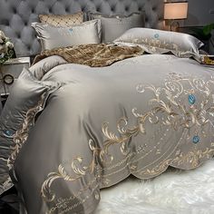 the bed is made with silver and gold comforters